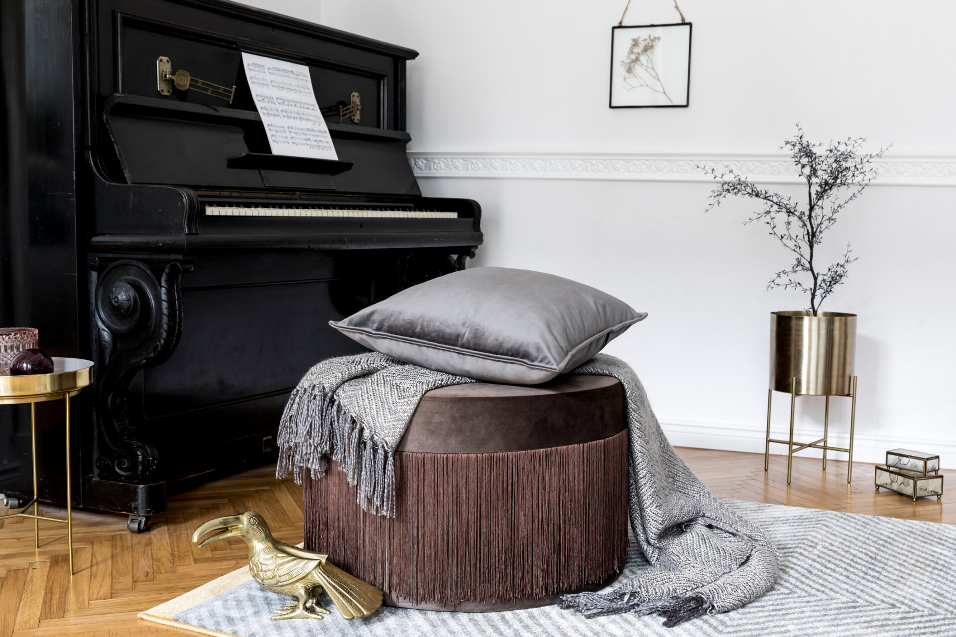 Stylish and luxury interior design of living room with brown velur pouf, pillows, plaid, sculpture, black piano, gold table, flowers and elegant personal accessories. Modern home decor. Template.