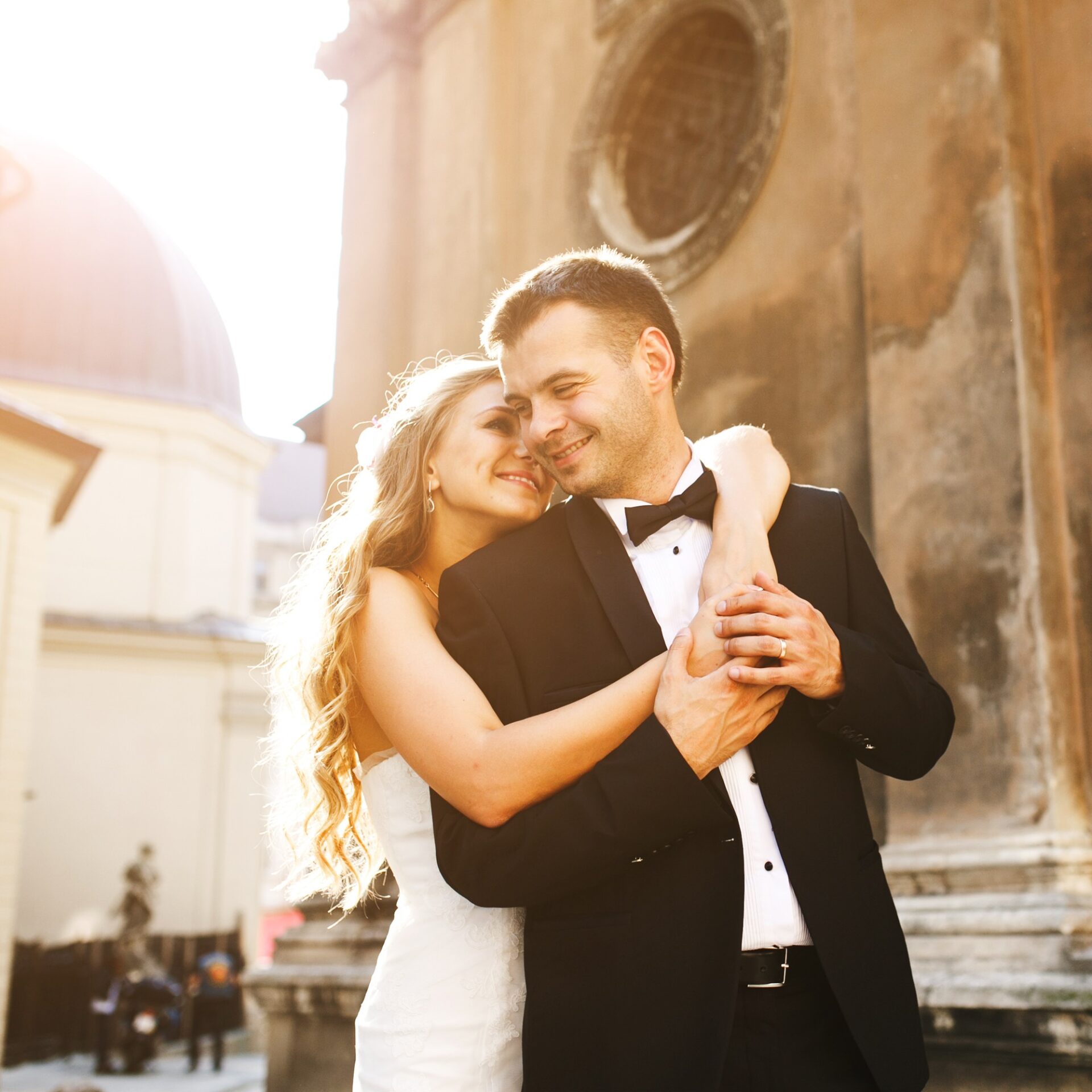Bride hugging groom from behind