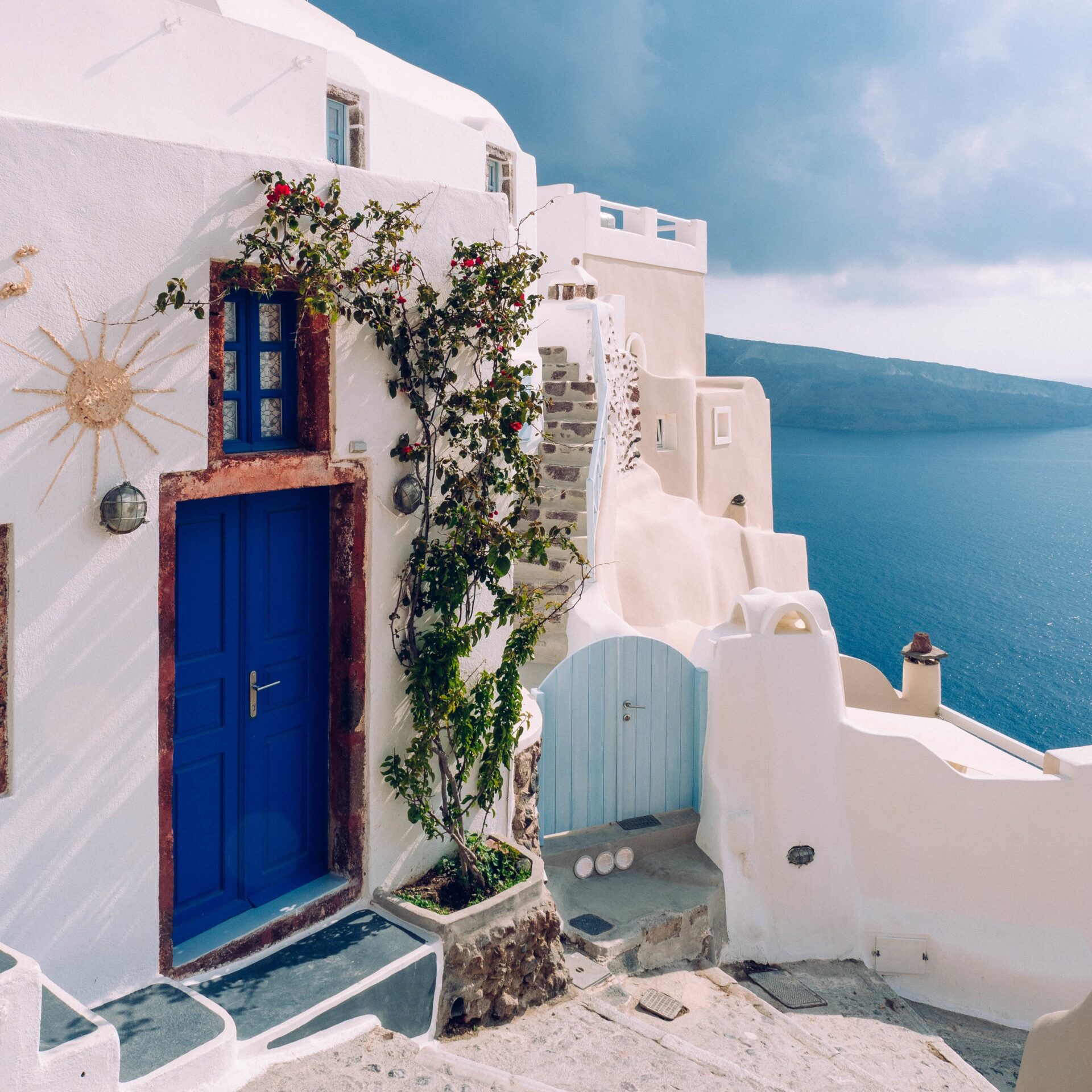 A vertical shot of a building with a blue door at Santorini, Greece