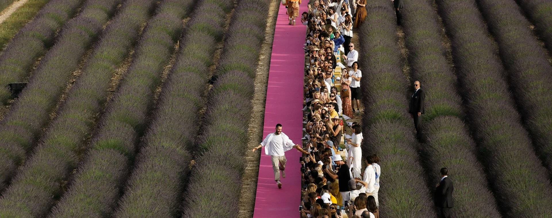 2026-Division-luxe-brand-Jacquemus-field-with-person-running-of-pink-carpet-hero-banner-desktop copy